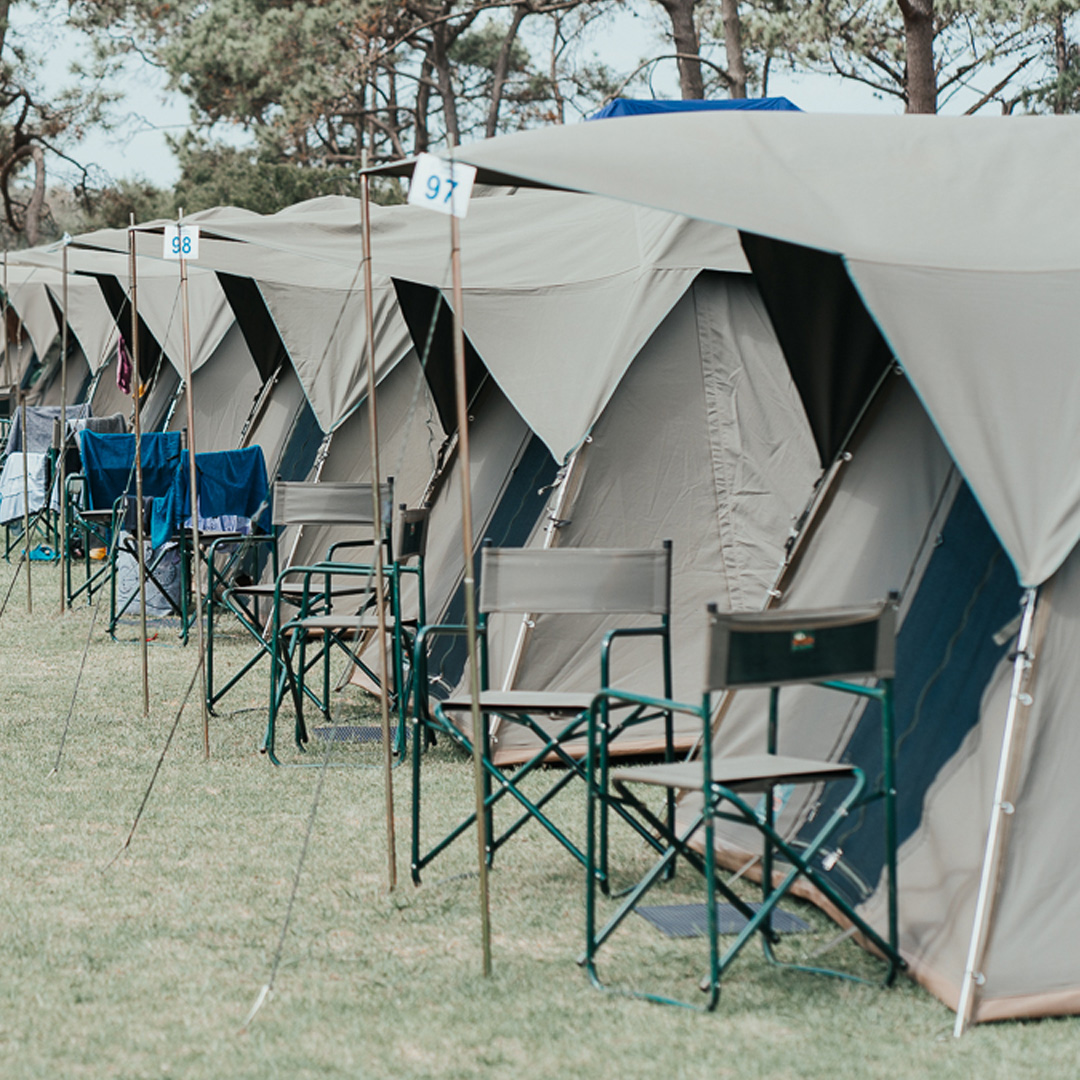 A row of luxury tents with chairs outside